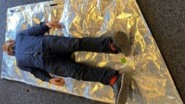 Čovek pozira ležeći na vreći