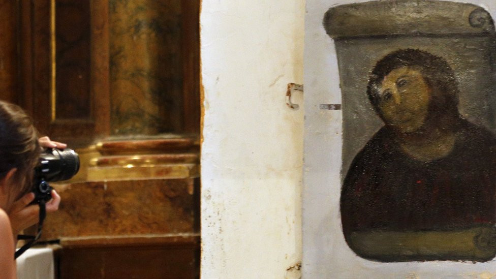 A tourist take a picture of the "restored" Ecce Homo