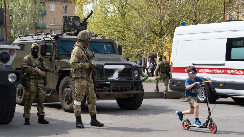 Russian forces and child on scooter
