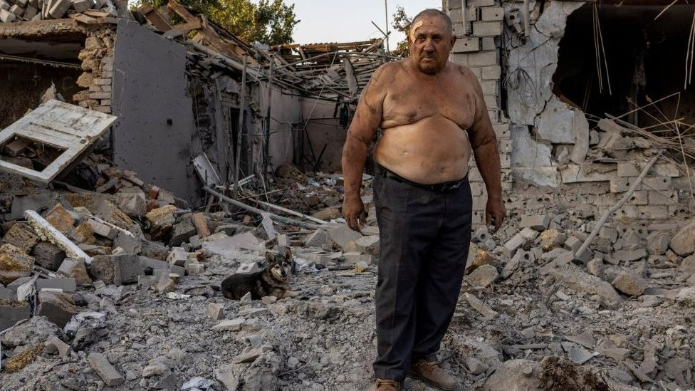 Alexander Shulga with his dog next to him reacts in front of his and his neighbour's home destroyed by a strike, amid Russia's invasion of Ukraine, in Mykolaiv, Ukraine, August 29, 2022. REUTERS/Umit Bektas TPX IMAGES OF THE DAY