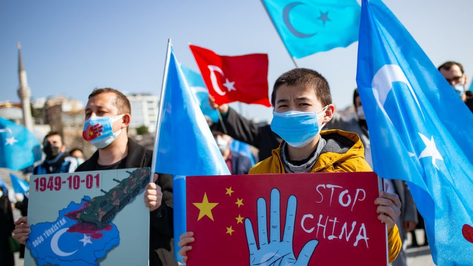 Pripadnici muslimanske ujgurske manjine drže transparente dok demonstriraju i traže vesti o zarobljenim rođacima