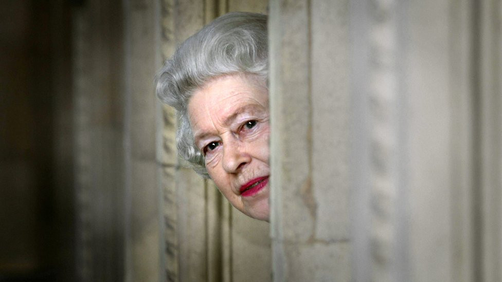 Queen Elizabeth II peers round a corner during a visit to the Royal Albert Hall in London, marking the end of an 8 year restoration program.