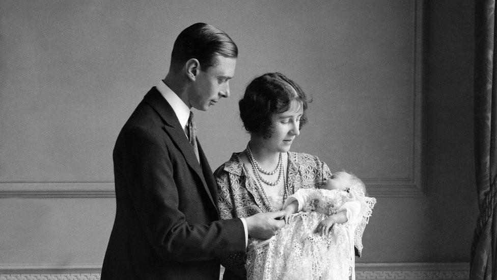 The Queen Mother (then the Duchess of York) with her husband, King George VI (then the Duke of York), and their daughter Queen Elizabeth II (then Elizabeth Alexandra Mary Windsor) at her christening in May 1926