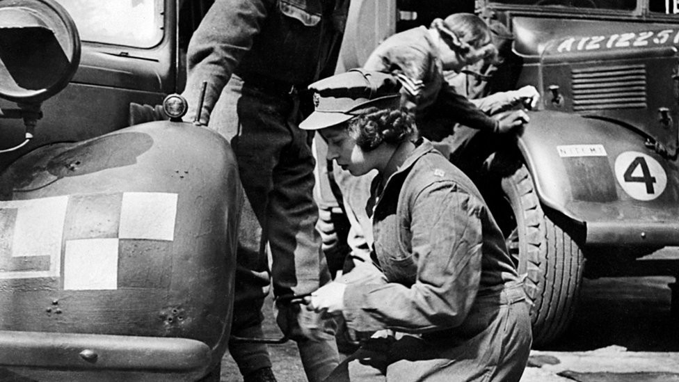 Princess Elizabeth changing the wheel of a military vehicle during World War Two, in an unknown location. 1940s