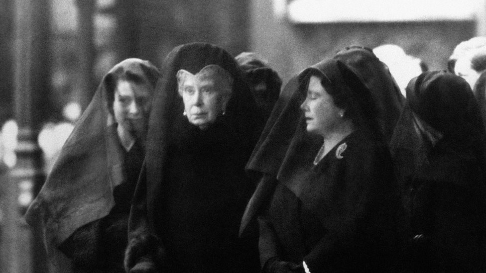 Queen Mary (centre) watches as the body of her son, George VI, is brought to Westminster Hall, London, for the lying-in-state. By her side, the Queen Mother, right, her eyes closed in grief. Queen Elizabeth II, veiled, stands behind her grandmother.