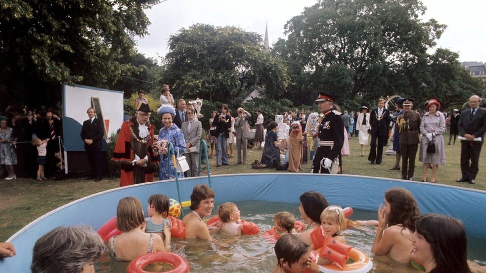 Queen Elizabeth II watches bathers in a pool at Parade Gardens, Bath, during her Silver Jubilee tour of Great Britain.