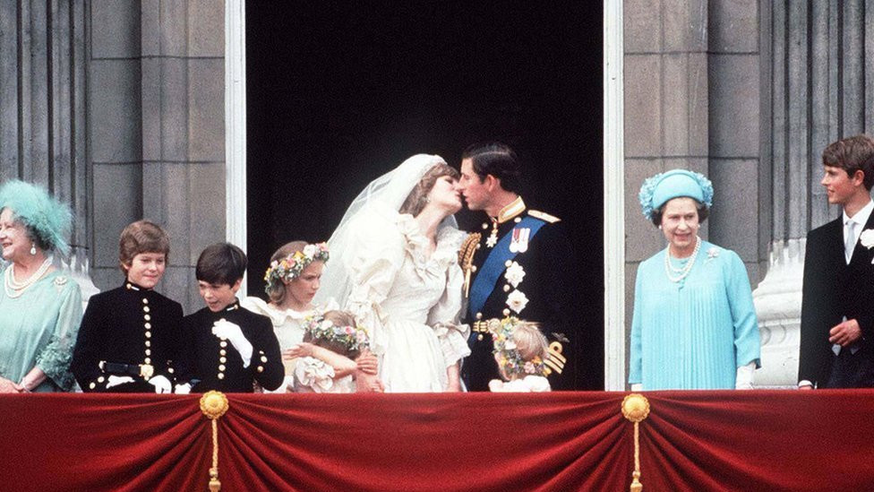 Prince Charles And Princess Diana kissing on The balcony of Buckingham Palace, 29 July 1981. They are surrounded by their bridesmaids and pageboys as well as Queen Elizabeth II, Prince Edward and the Queen Mother.
