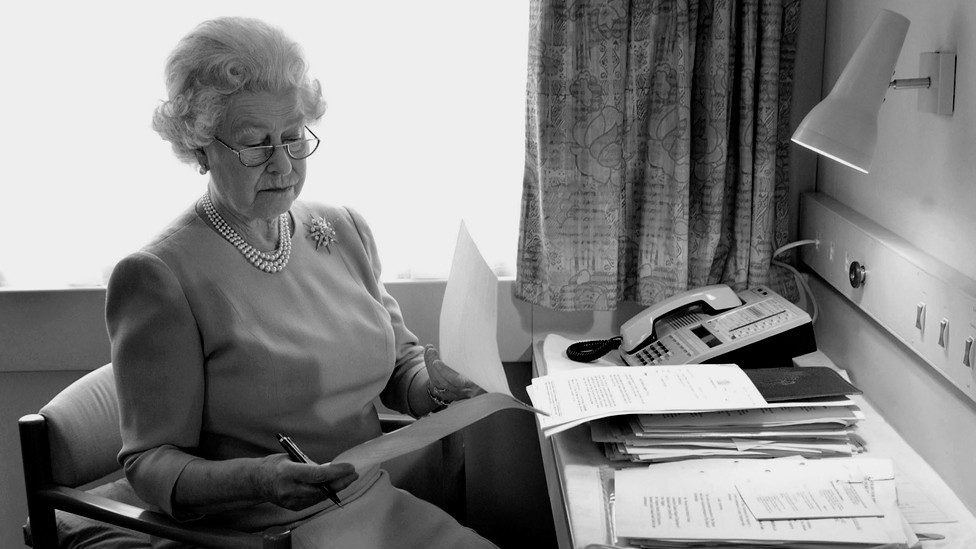 Queen Elizabeth II works at her desk on the Royal Train in May of 2002.