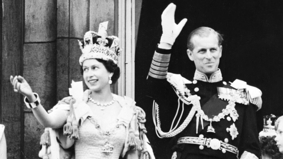Queen Elizabeth II accompanied by Prince Philip waves to the crowd, 02 June 1953
