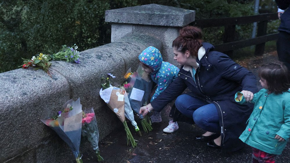Žena postavlja cveće na ulazu u zamak Balmoral