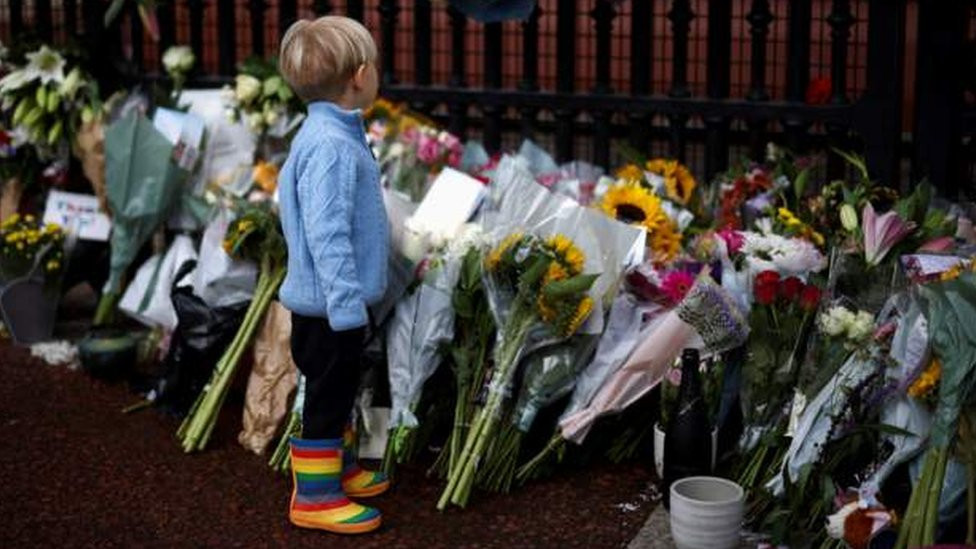 Ljudi dolaze sa decom da odaju poštu i polože cveće ispred kapije Bakingemske palate