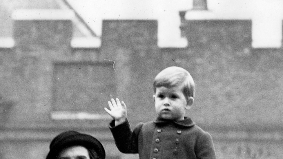 Čarls maše publici sa zida Klarens hausa u Londonu. Čvrsto ga drži medicinska sestra Lajtbodi, na vidikovcu sa kojeg je posmatrao bake i dede, kralja i kraljicu, i majku, princezu Elizabetu, kako se voze u Vestminster