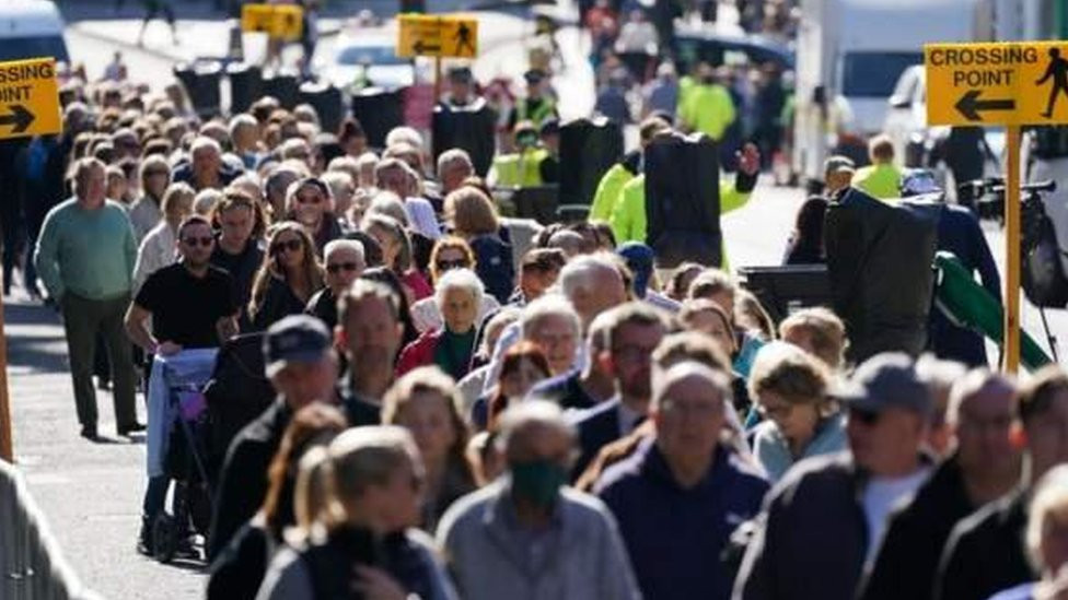 ljudi u povorci čekaju da odaju poštu kraljici