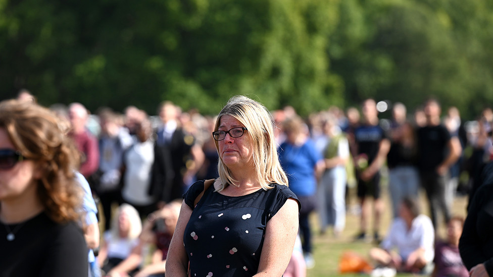 A tearful mourner watch's the procession for the Lying-in State of Queen Elizabeth II at the Hyde Park screening site on 14 September 2022 in London