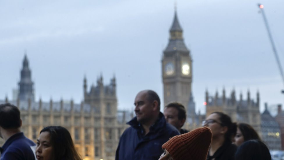 ljudi u povorci čekaju da odaju poštu kraljici