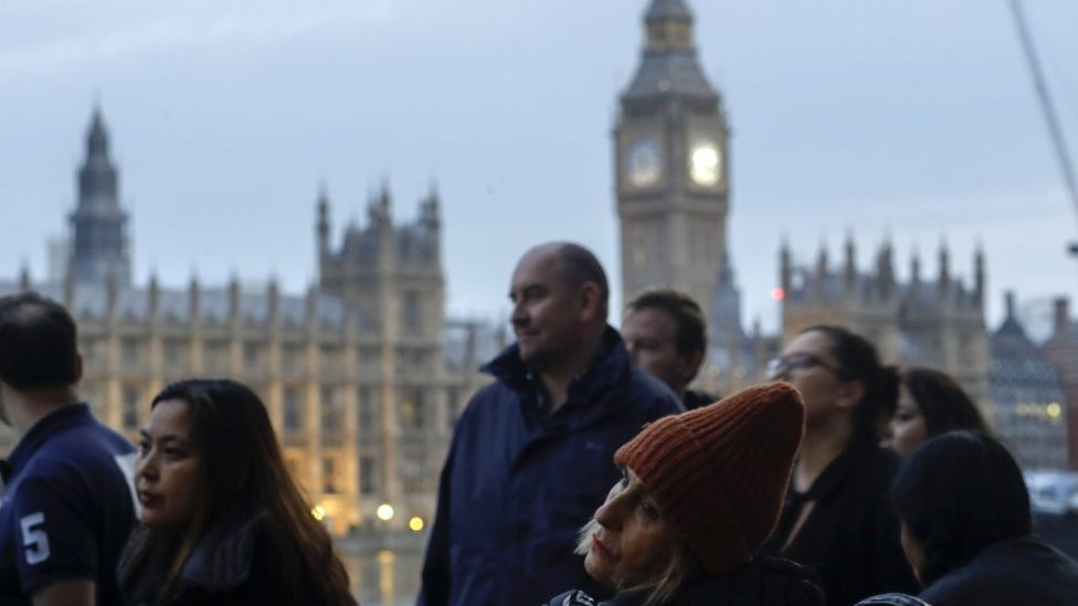 ljudi u povorci čekaju da odaju poštu kraljici