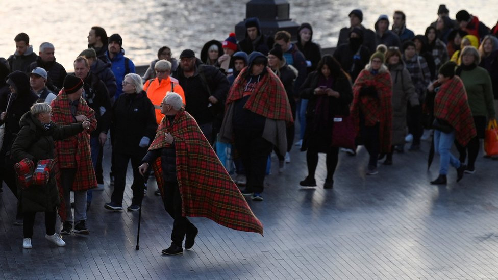 People wearing protective blankets in the queue near Tower Bridge