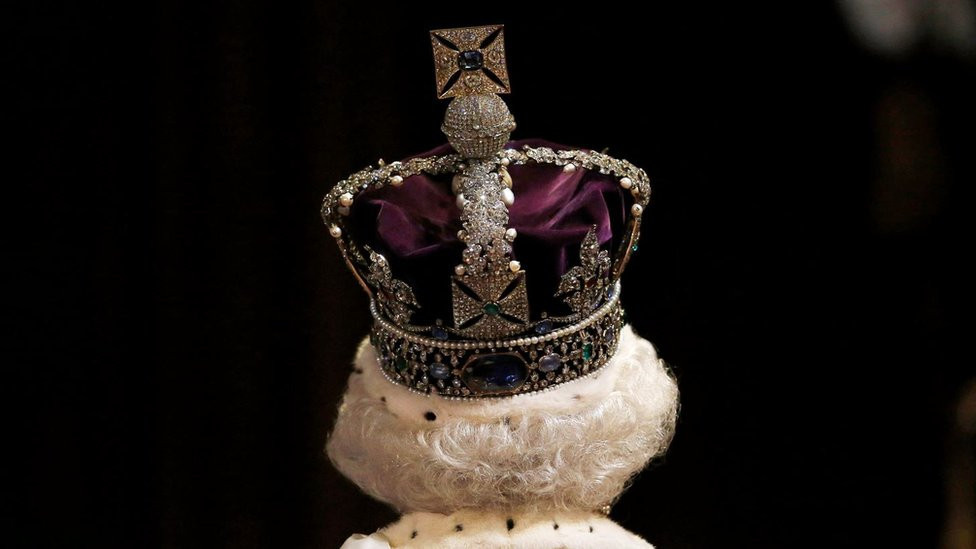 Queen Elizabeth's head and shoulders with her crown on her head, viewed from behind while leaving the state opening of the UK parliament