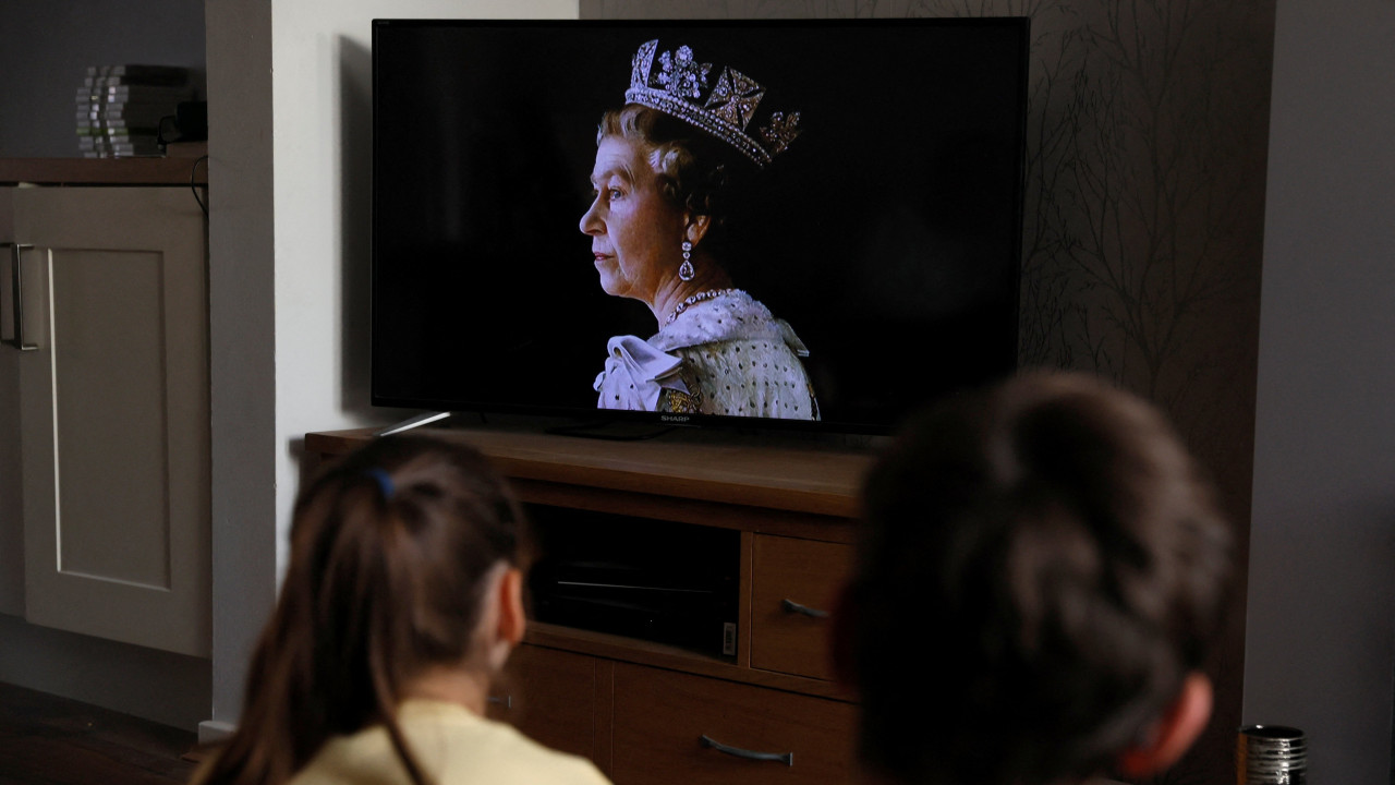 Children watch TV as it is announced that Queen Elizabeth, Britain's longest-reigning monarch and the nation's figurehead for seven decades, died aged 96