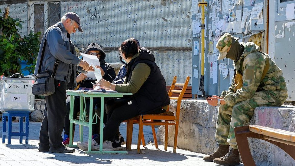 Stanovnik Marijupolja dobija glasački listić pre nego što će ubaciti glas u mobilnu kutiju tokom nepriznatog referenduma u okupiranim ukrajinskim teritorijama, Marijupolj 25. septembar