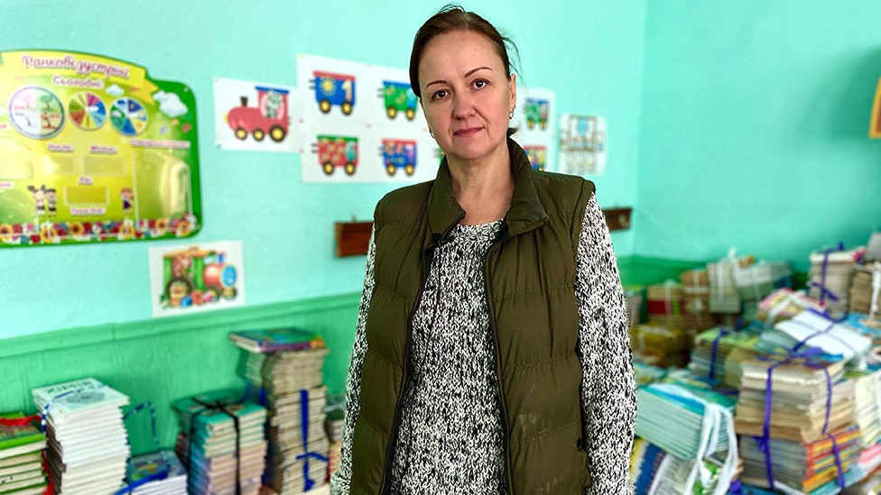 Liliya stood in a room with piles of text books