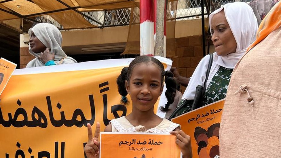 Girl holding poster saying: Where is the punishment