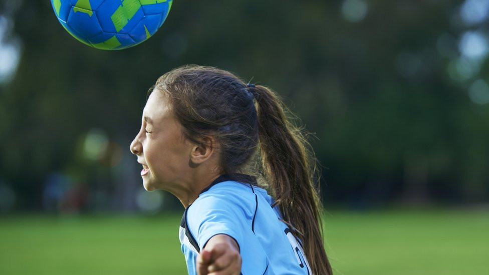 girl heading a football