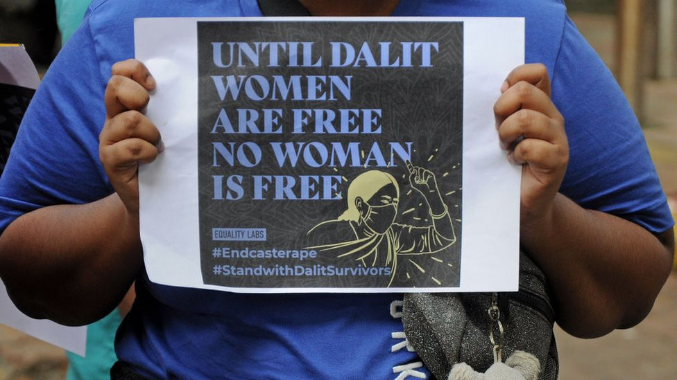 A protester holds a placard during a demonstration against caste-based sexual violence.