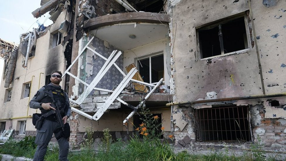 Vojin garde za hitne slučajeve (ERU) stoji ispred oštećene zgrade u Irpinu