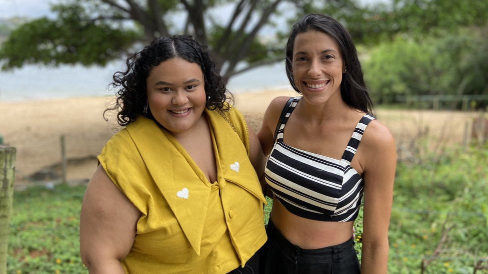 Friends Rayane and Mariana smile at the beach