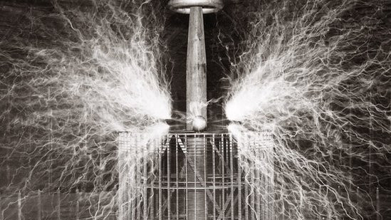 Nikola Tesla (1856-1943), Serbian-American physicist sitting in his Colorado Springs laboratory with his "Magnifying transmitter" - 1899