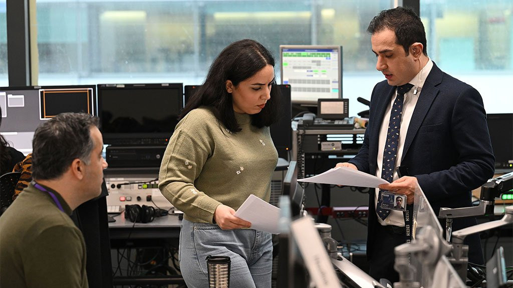 Parham Ghobadi (R) chats with BBC Persian staff in the office