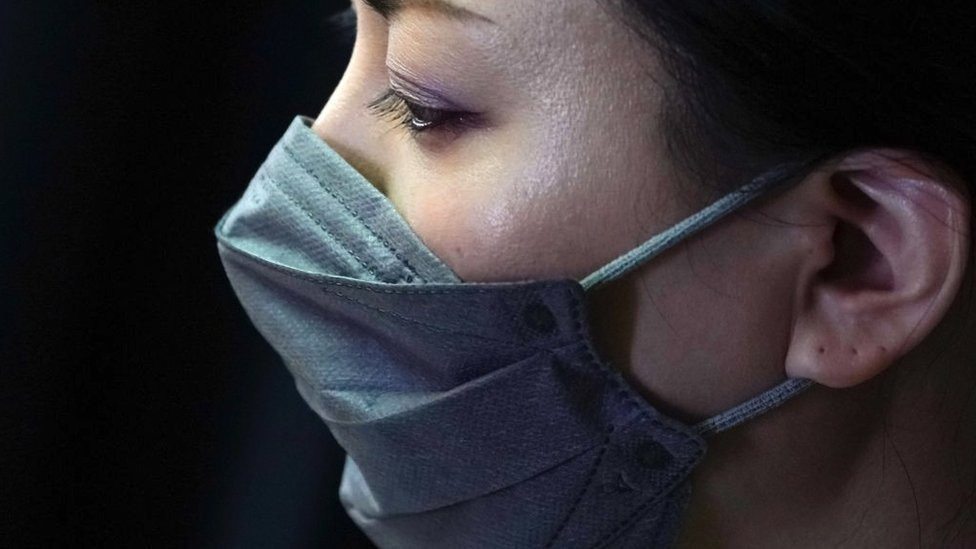 A performing artist and entertainer trained in traditional styles called "geisha" wears a face mask as she takes part in a training session