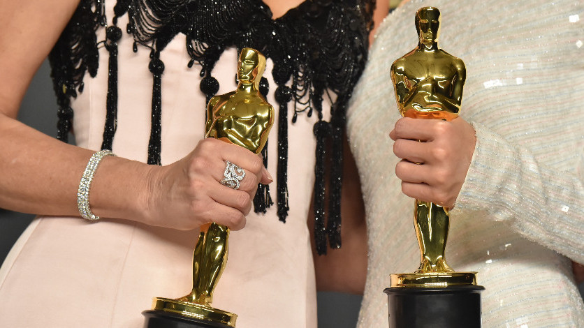 Two winners holding Oscars statues