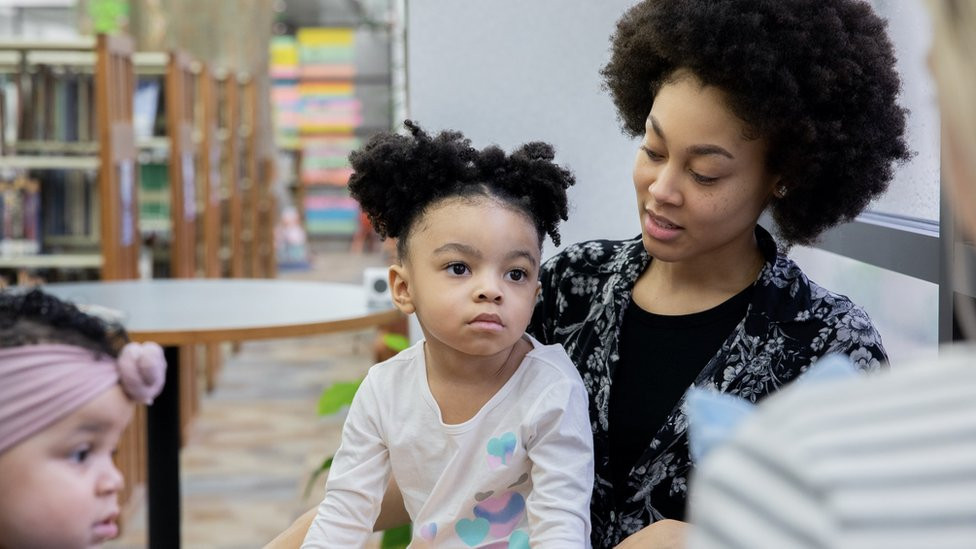 A mother and daughter take part in a discussion with another girls and a teacher