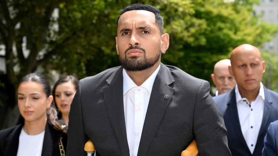 Nick Kyrgios arrives at court on crutches