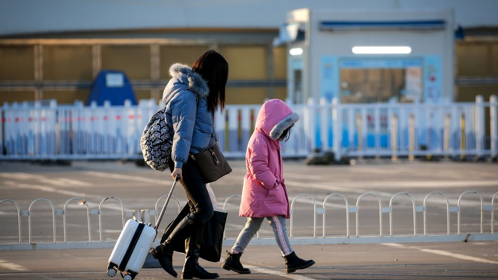 Žena i dete sa koferom