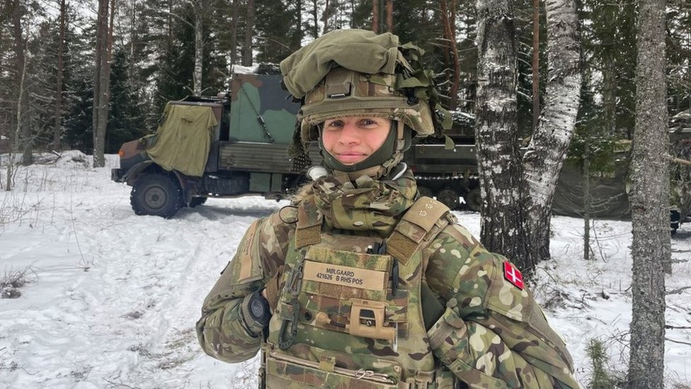 Danka vojnikinja pored kamiona u šumi
