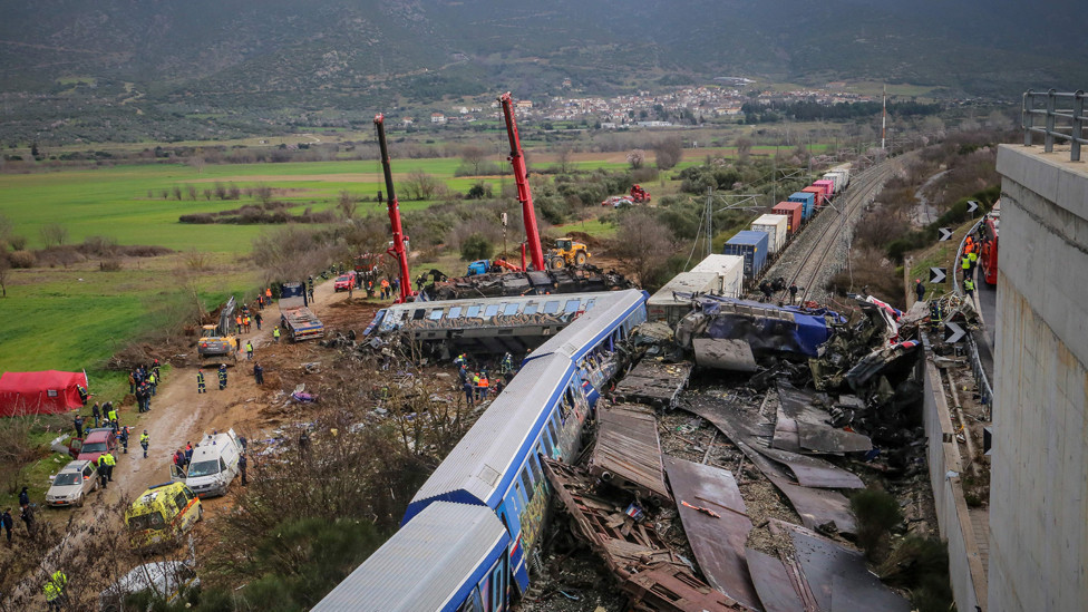 Police and emergency crews search the debris of a crushed wagon after the train accident.