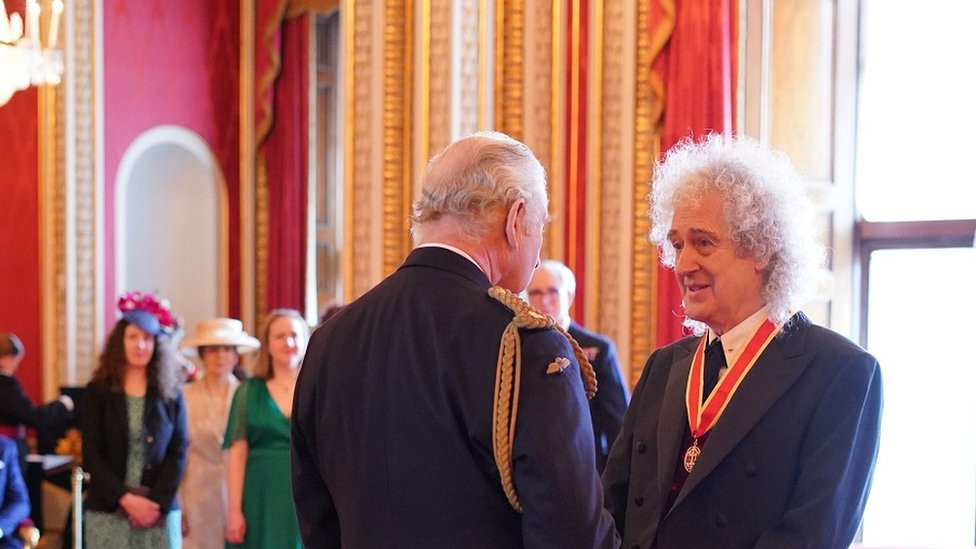 King Charles chats with Brian May after knighting him at Buckingham Palace