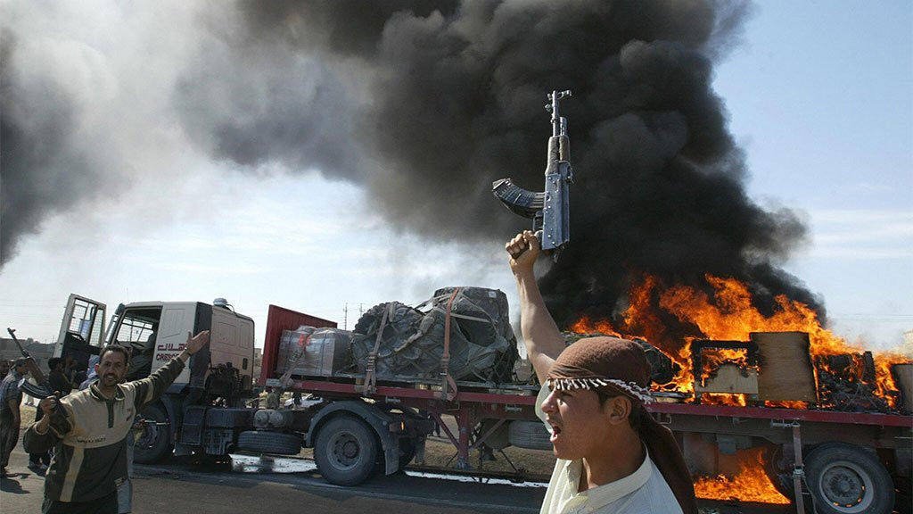 Irački pobunjenici iz redova suni muslimana ispred američkog konvoja u plamenu u predgrađu Faludže 2004