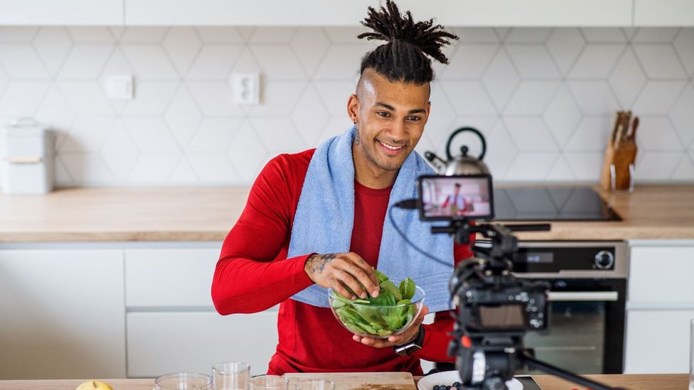 Fitness vlogger making a video of himself at home