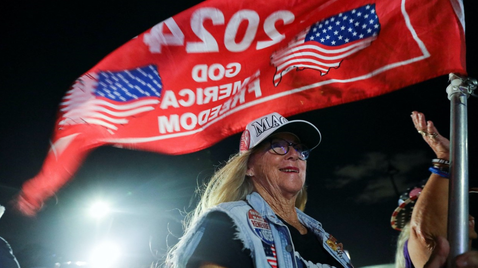 A supporter of former U.S. President Donald Trump attends a gathering outside his Mar-a-Lago resort after hearing news of Trump's indictment