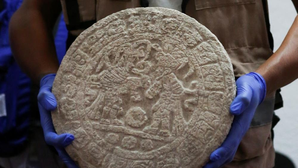 A worker shows a circular-shaped Mayan scoreboard used for a ball game found at Chichen Itza's archaeological site during a news conference, in Merida, Mexico April 11, 2023.