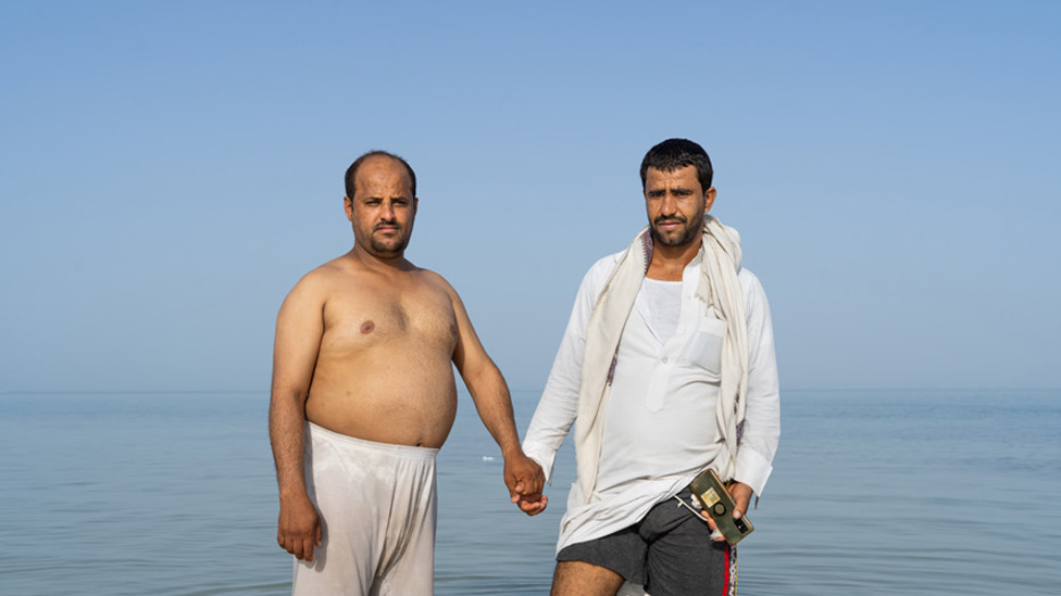 Dva čoveka su moru, držeći se za ruke