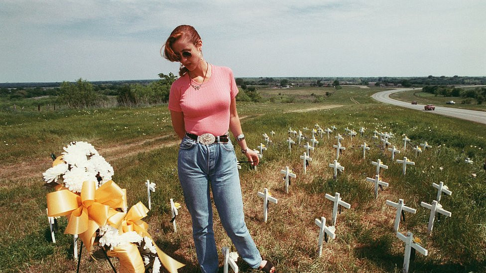 A woman stands among the graves of victims of the Waco tragedy