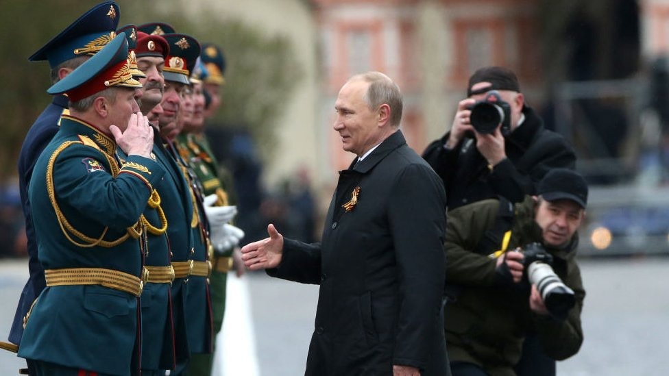 Russian President Vladimir Putin greets members of the military