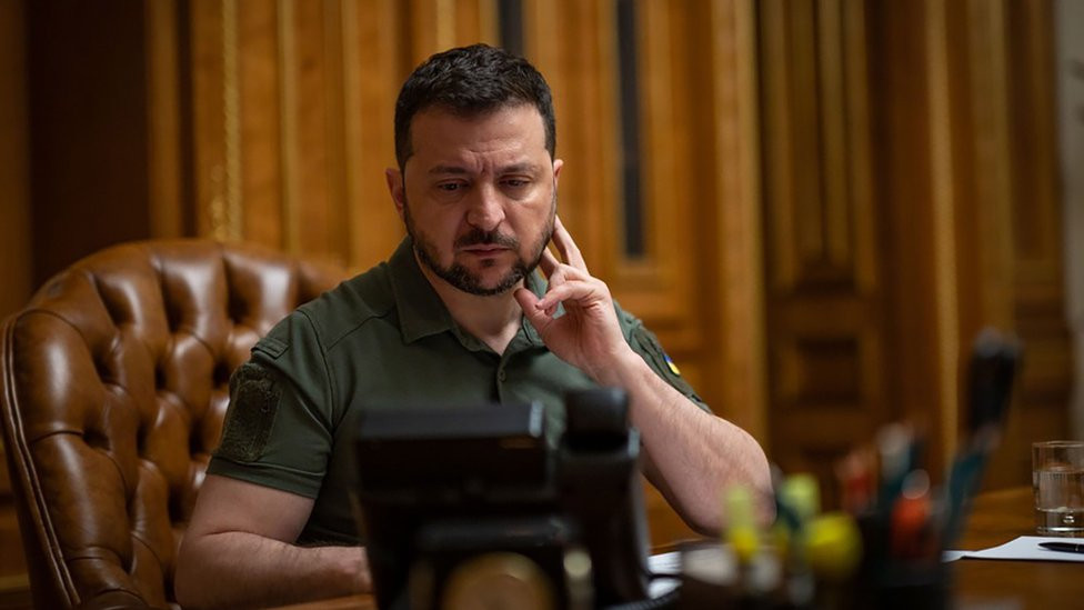 President Volodymyr Zelensky sitting at a desk