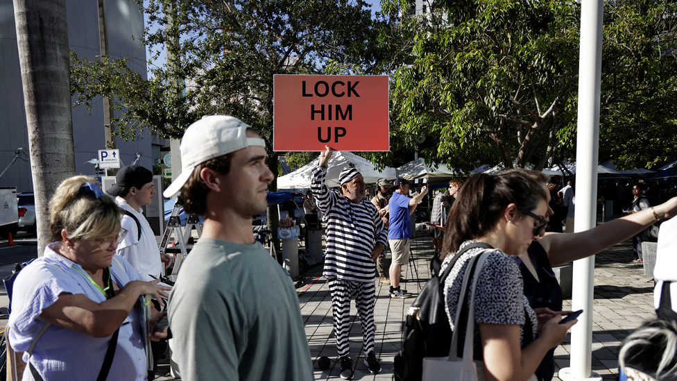 A Trump opponent holds a sign outside the Wilkie D. Ferguson Jr. United States Federal Courthouse where former President Donald Trump is set to appear in front of a judge on June 13, 2023 in Miami, Florida