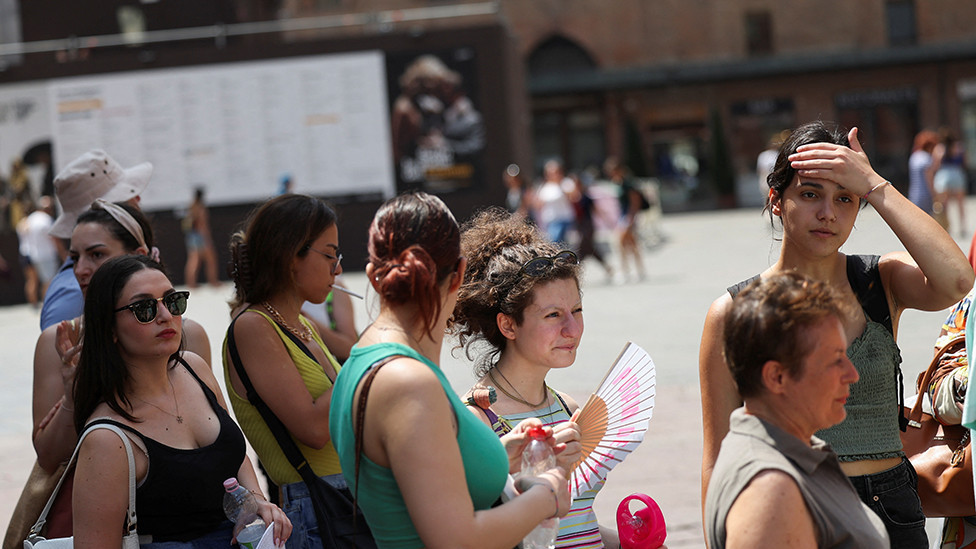 People queue in the heat in Bologna, Italy, on 18 July 2023